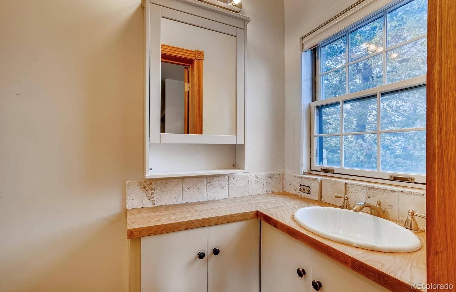 1150 North Madge Gulch Road Sedalia, CO 80135 - Photo 36 of 49 a bathroom with a sink and a window