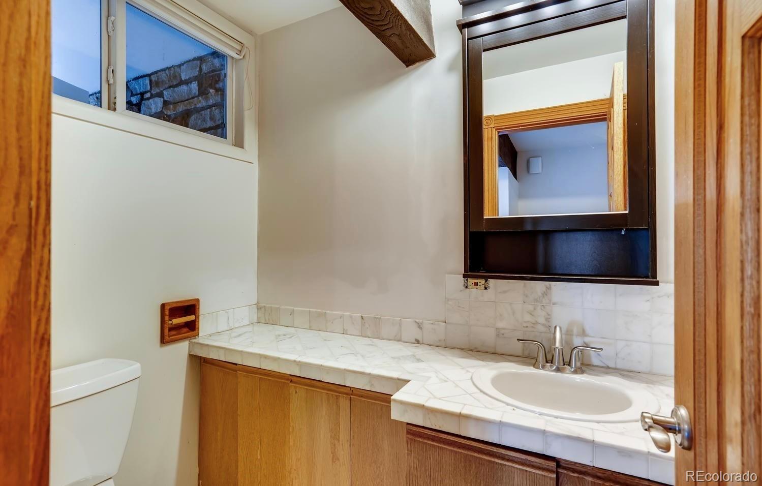 1150 North Madge Gulch Road Sedalia, CO 80135 - Photo 37 of 49 a bathroom with a sink and a mirror
