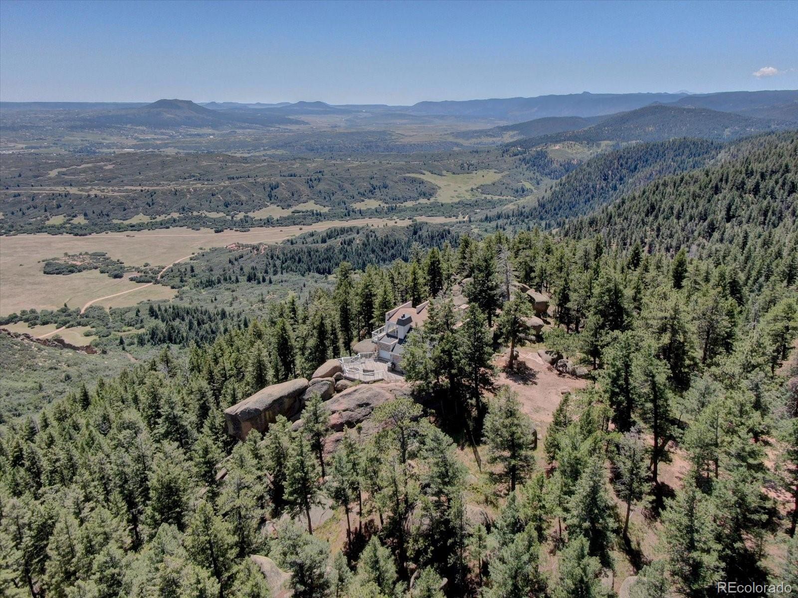 1150 North Madge Gulch Road Sedalia, CO 80135 - Photo 46 of 49 a view of a field with a forest