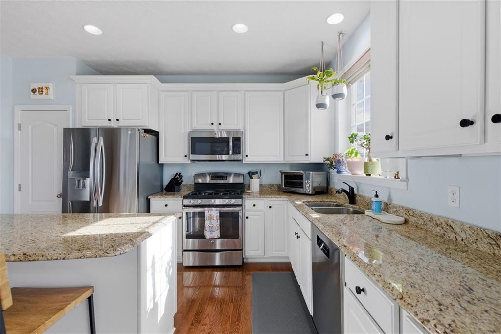 44 Coolidge Drive McKees Rocks, PA 15136 - Photo 14 of 36 a kitchen with kitchen island granite countertop a sink stainless steel appliances and white cabinets