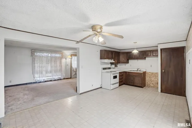 a large white kitchen with a sink stainless steel appliances and cabinets