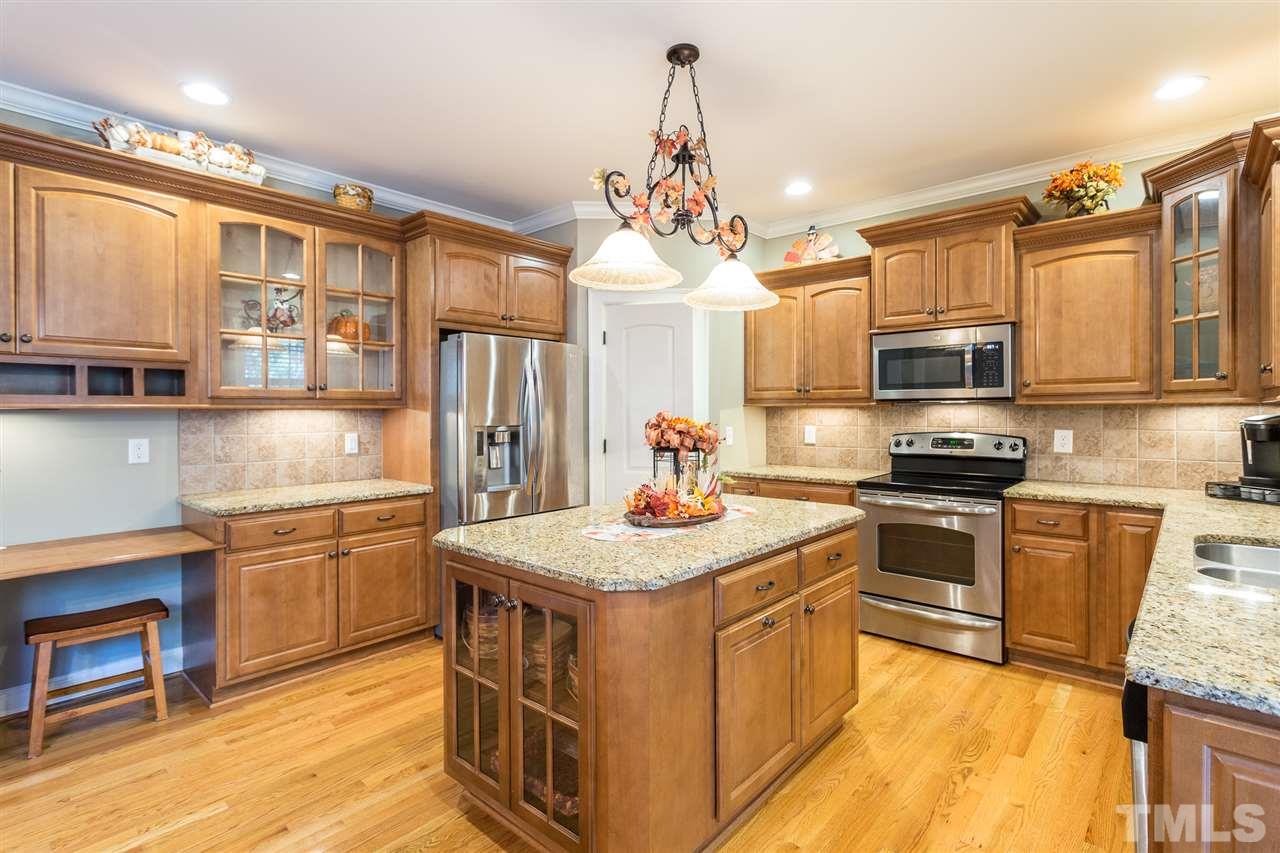12 Vista Ridge Drive Willow Spring, NC 27592 - Photo 12 of 30 This well-appointed kitchen boasts lots of counter space for food prep. A built-in desk provides additional work space. The raised panel cabinetry features crown & rope trim, glass panels, pull out trash bin, cookie sheet cab. & a lazy Susan. W-in pantry.