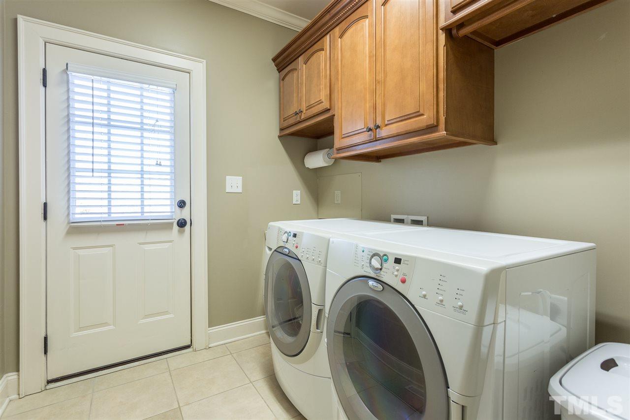 12 Vista Ridge Drive Willow Spring, NC 27592 - Photo 15 of 30 This first floor laundry room features raised panel cabinets, a utility sink, crown molding and tile flooring.