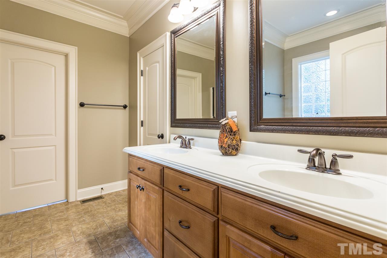 12 Vista Ridge Drive Willow Spring, NC 27592 - Photo 17 of 30 This lovely master bath boasts a spacious vanity with dual sinks which is graced by framed mirrors and oil rubbed bronze fixtures and hardware. Heavy trim and tile flooring add to the beauty of this elegant room.