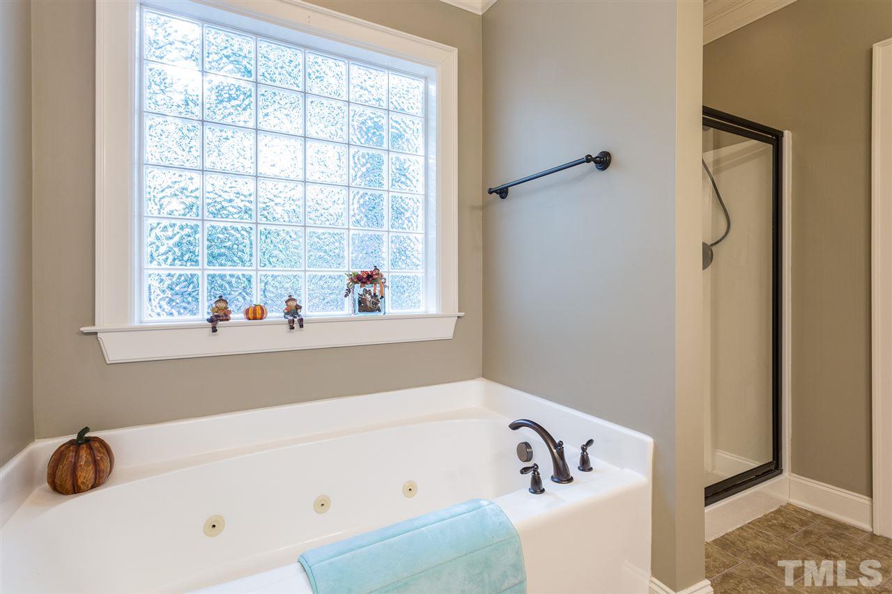 12 Vista Ridge Drive Willow Spring, NC 27592 - Photo 18 of 30 This lovely master bath features heavy trim, tile flooring, a water closet, and a jetted tub and separate shower. Room also boasts oil rubbed bronze fixtures and hardware and dual sinks.