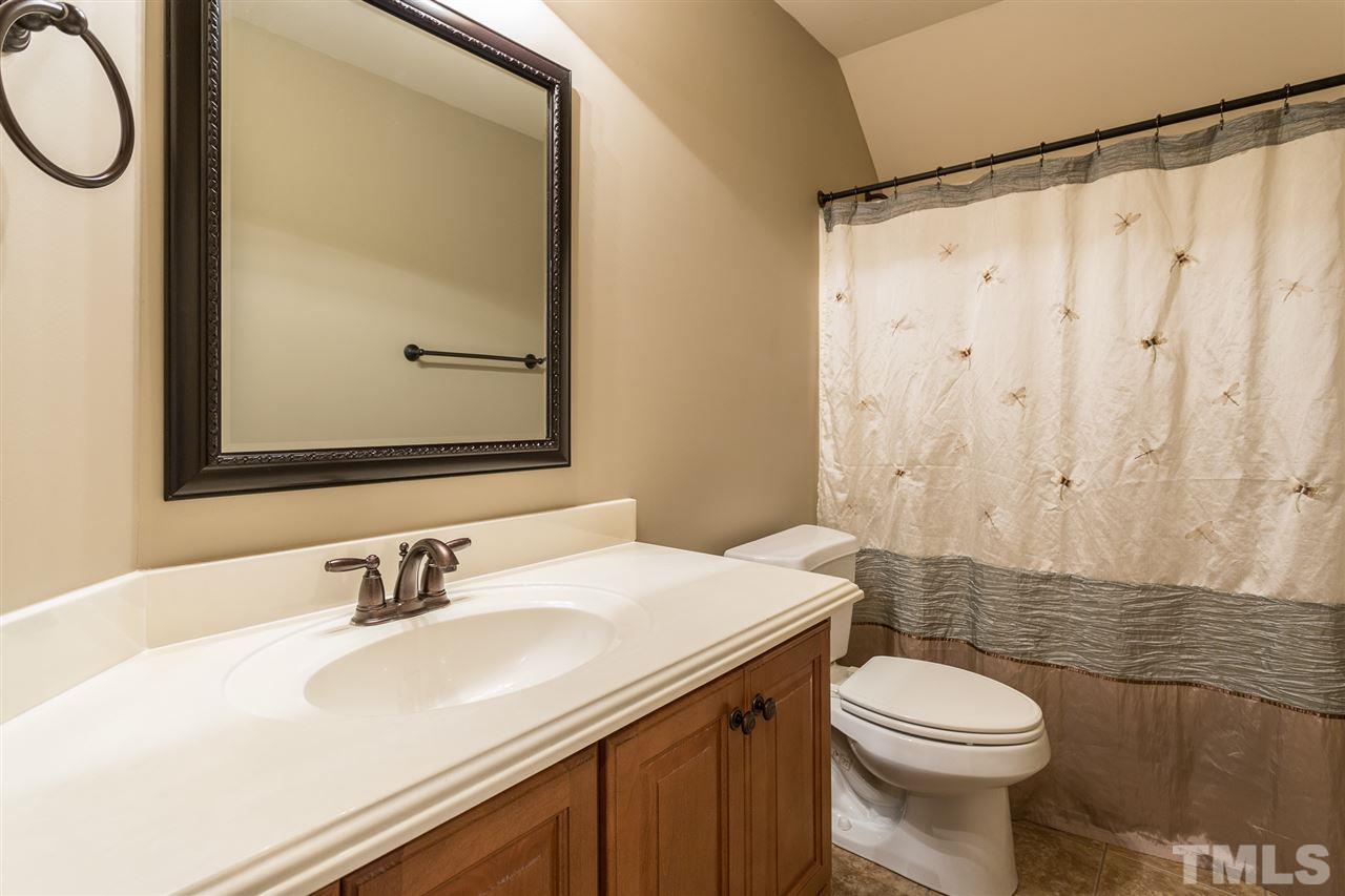 12 Vista Ridge Drive Willow Spring, NC 27592 - Photo 22 of 30 This lovely upstairs hall bath features raised panel cabinets with oil rubbed bronze hardware, a framed mirror, and tile flooring.