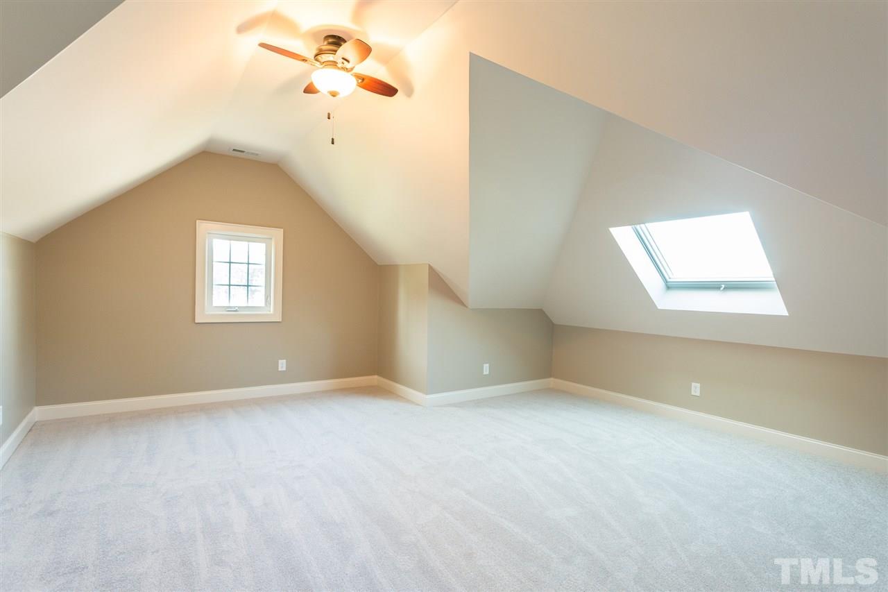 12 Vista Ridge Drive Willow Spring, NC 27592 - Photo 23 of 30 Step down into this spacious bonus room which has many options for its usage. Room features new carpet, a ceiling fan with light, and a skylight to let in additional lighting.