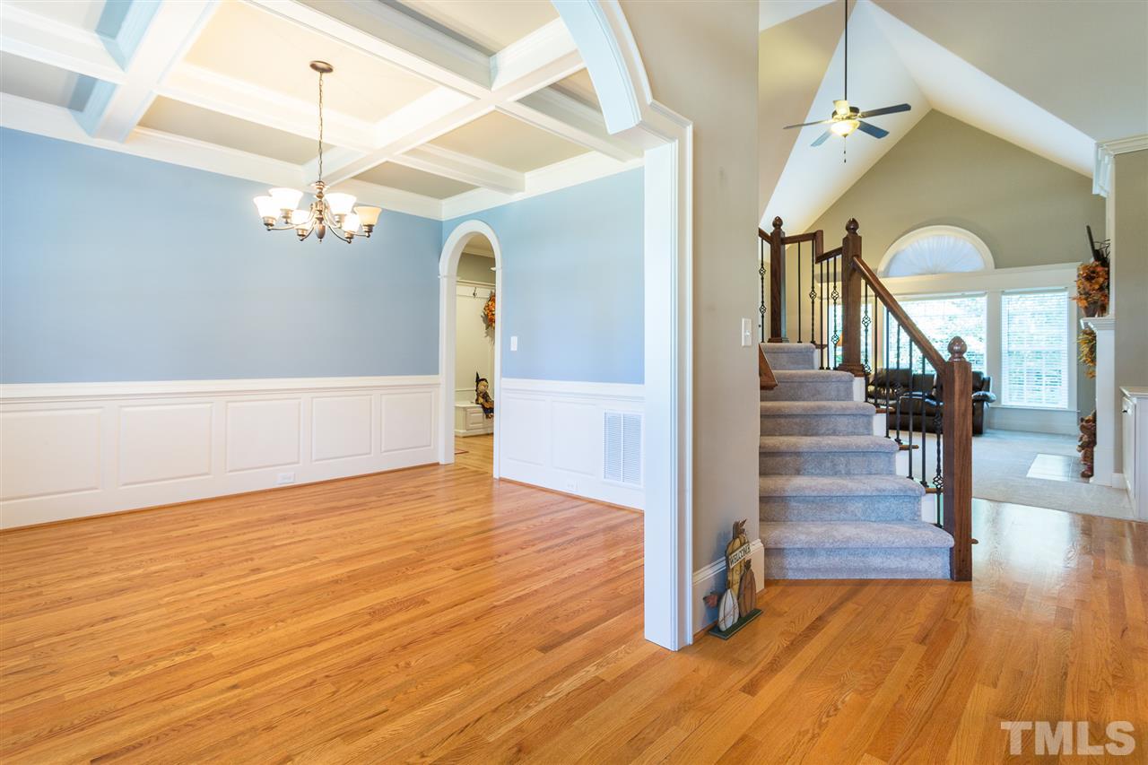 12 Vista Ridge Drive Willow Spring, NC 27592 - Photo 5 of 30 A beautiful view from the entry foyer of the formal dining room. This elegant dining room features an arched entry way with heavy trim, a coffered ceiling with an oil rubbed bronze light fixture, chair railing, wainscoting, and beautiful hardwood floors.