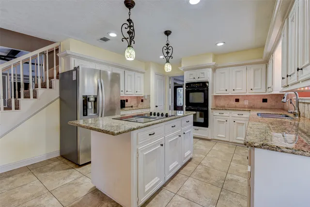 a kitchen with stainless steel appliances granite countertop a stove and a refrigerator