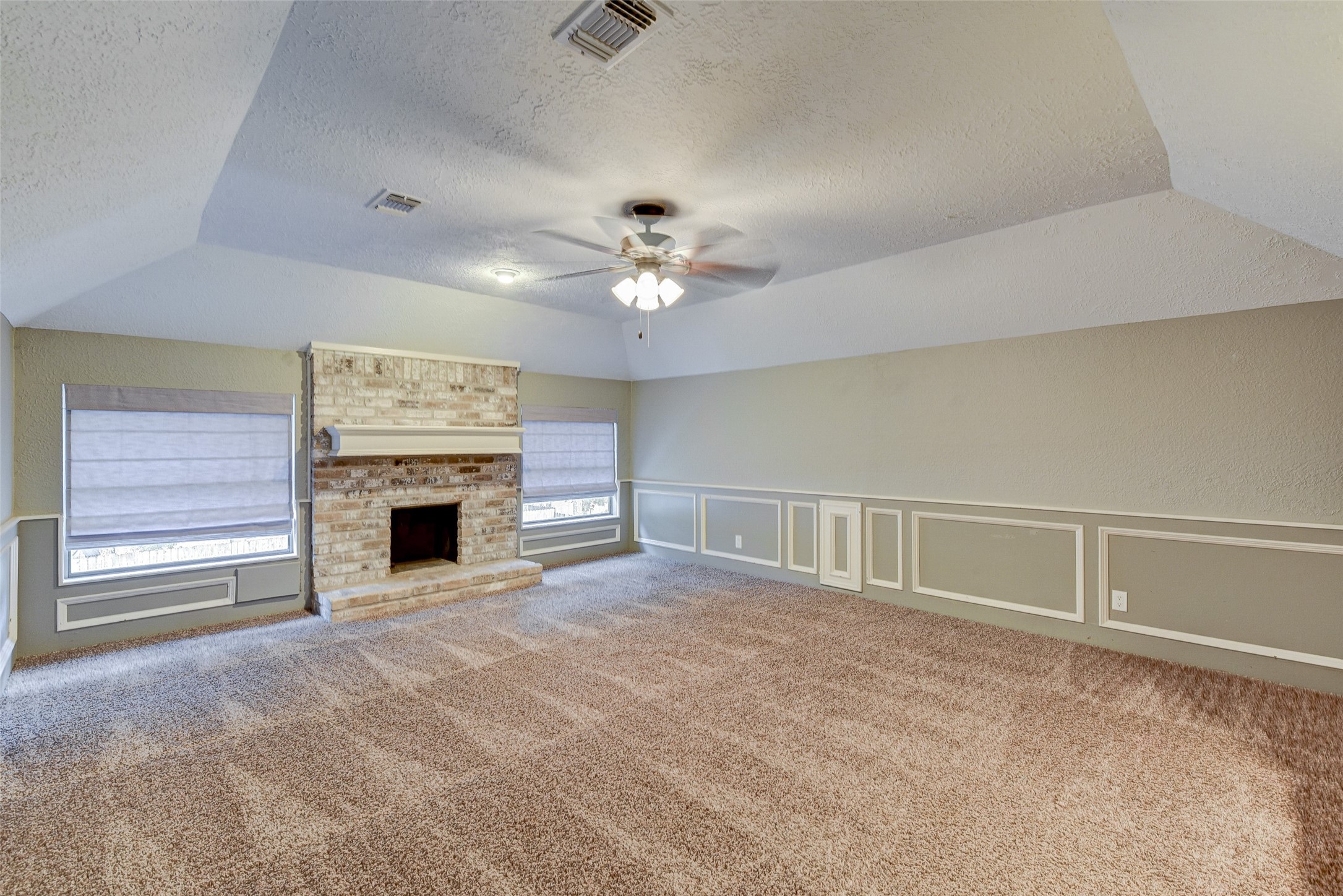 18310 Lake Oaks Drive Spring, TX 77388 - Photo 19 of 31 a view of an empty room with a fireplace and a ceiling fan