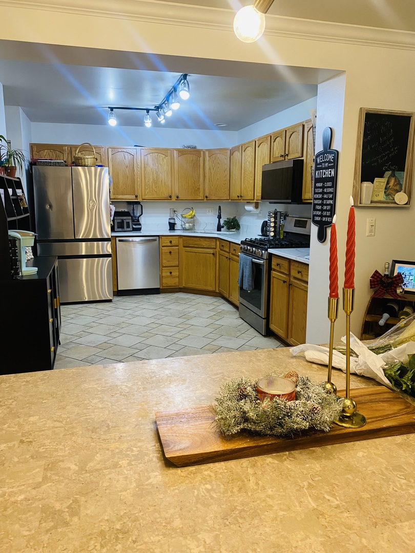 2745 Borkshire Lane, Unit 2745 Aurora, IL 60502 - Photo 9 of 23 a kitchen with stainless steel appliances kitchen island granite countertop a sink refrigerator stove and microwave