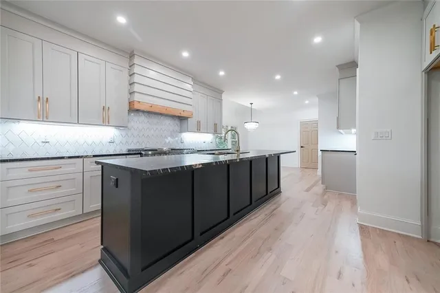a kitchen with granite countertop a sink and cabinets