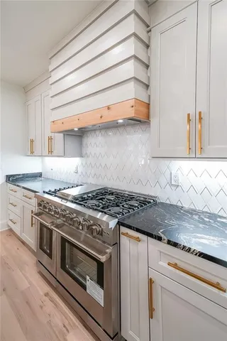 a kitchen with granite countertop a stove and a sink