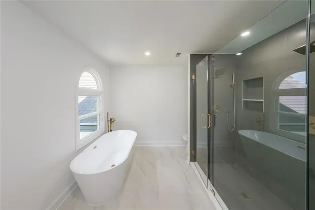 a spacious bathroom with a bathtub and shower