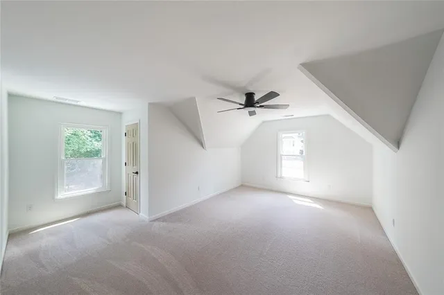 a view of a big room with windows and chandelier fan