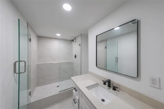 a bathroom with a sink a toilet and shower