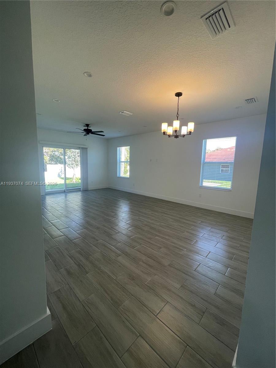 912 West 10th Street Riviera Beach, FL 33404 - Photo 15 of 24 an empty room with chandelier fan and wooden floor