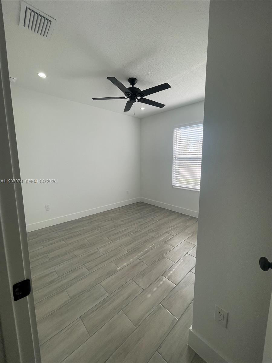912 West 10th Street Riviera Beach, FL 33404 - Photo 6 of 24 an empty room with windows and fan