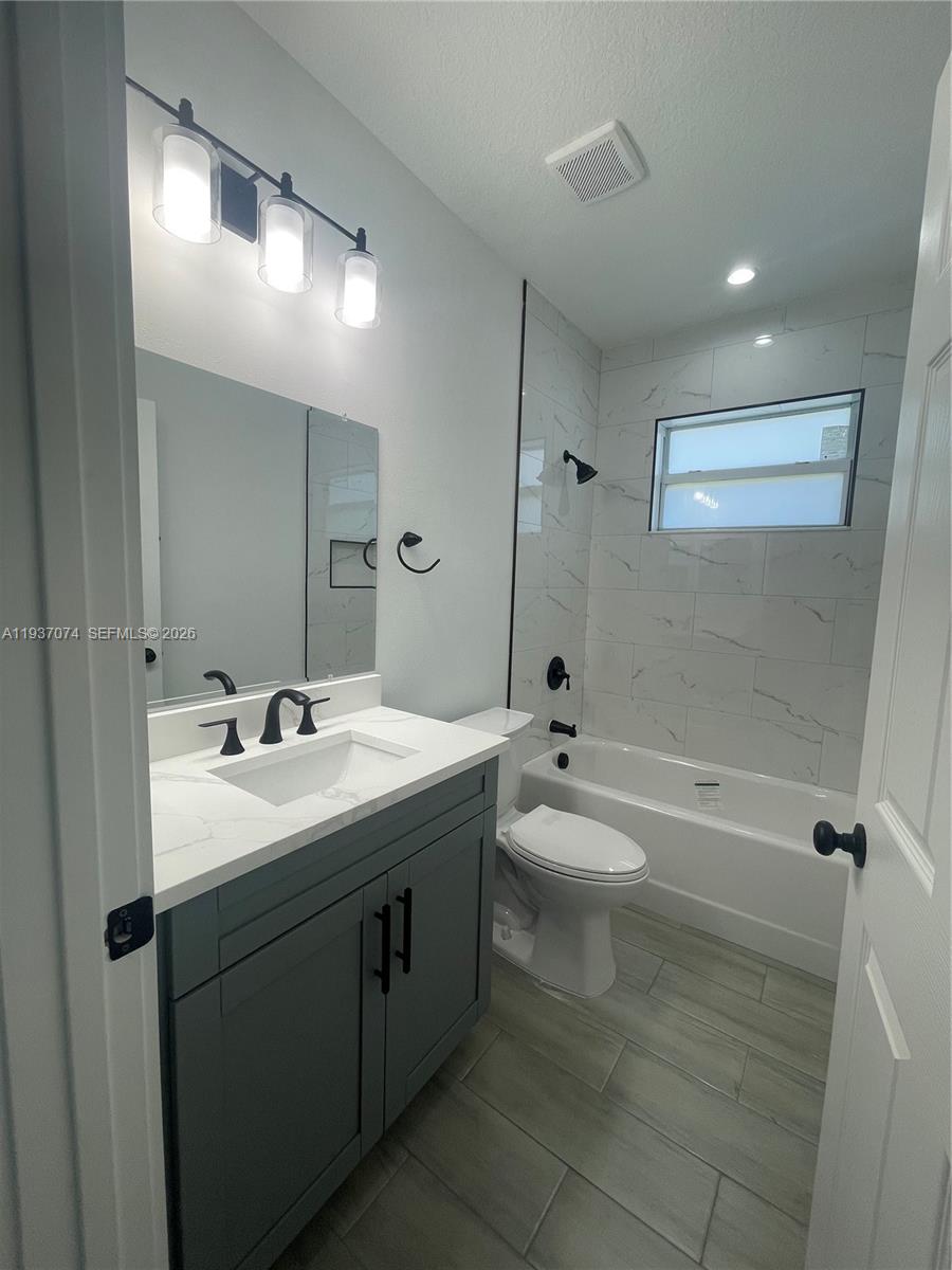 912 West 10th Street Riviera Beach, FL 33404 - Photo 10 of 24 a bathroom with a toilet a sink and bathtub