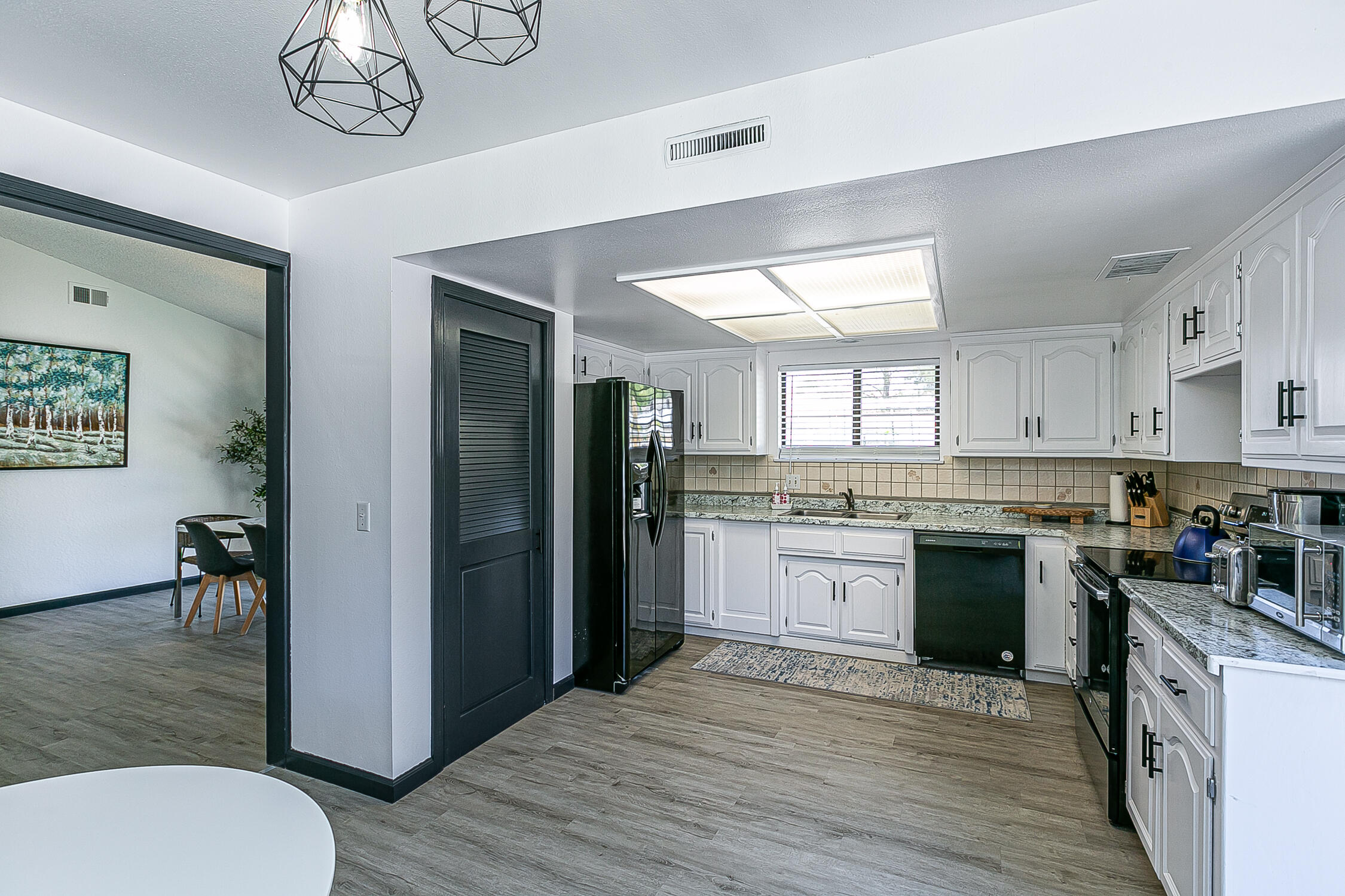 5375 Campbell Road Lompoc, CA 93436 - Photo 14 of 48 a kitchen with a refrigerator a stove a sink a dining table and chairs