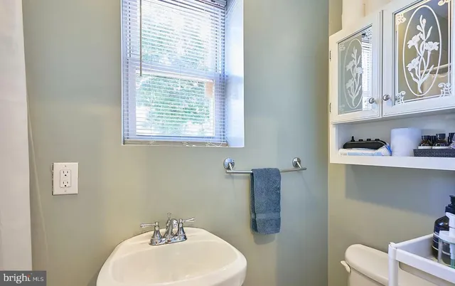 a bathroom with a sink a toilet and a window