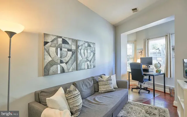 a living room with furniture and a painting on the wall