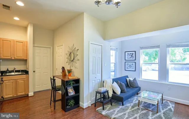 a living room with furniture a desk and chair with wooden floor