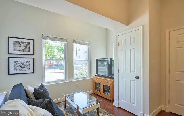 a living room with furniture a window and a flat screen tv