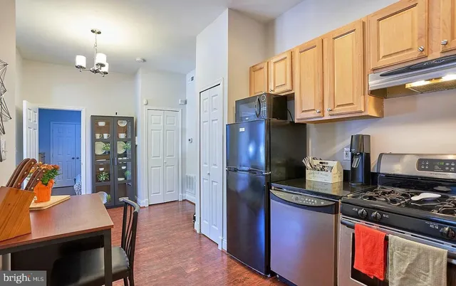 a kitchen with stainless steel appliances granite countertop a stove refrigerator and cabinets