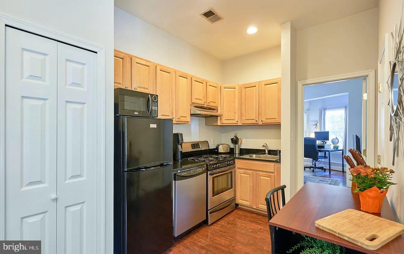 500 Florida Avenue Northwest, Unit 1 Washington, DC 20001 - Photo 10 of 20 a kitchen with stainless steel appliances granite countertop a refrigerator a stove a sink dishwasher and white cabinets with wooden floor