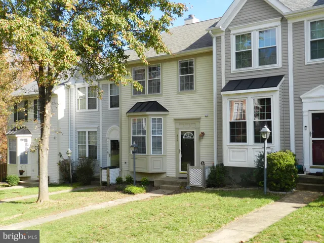 a view of a white house with large windows and a yard