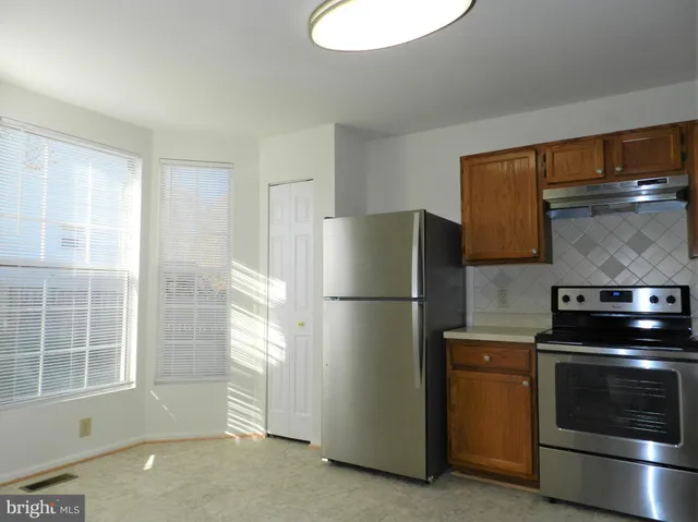 a kitchen with a stove top oven and refrigerator