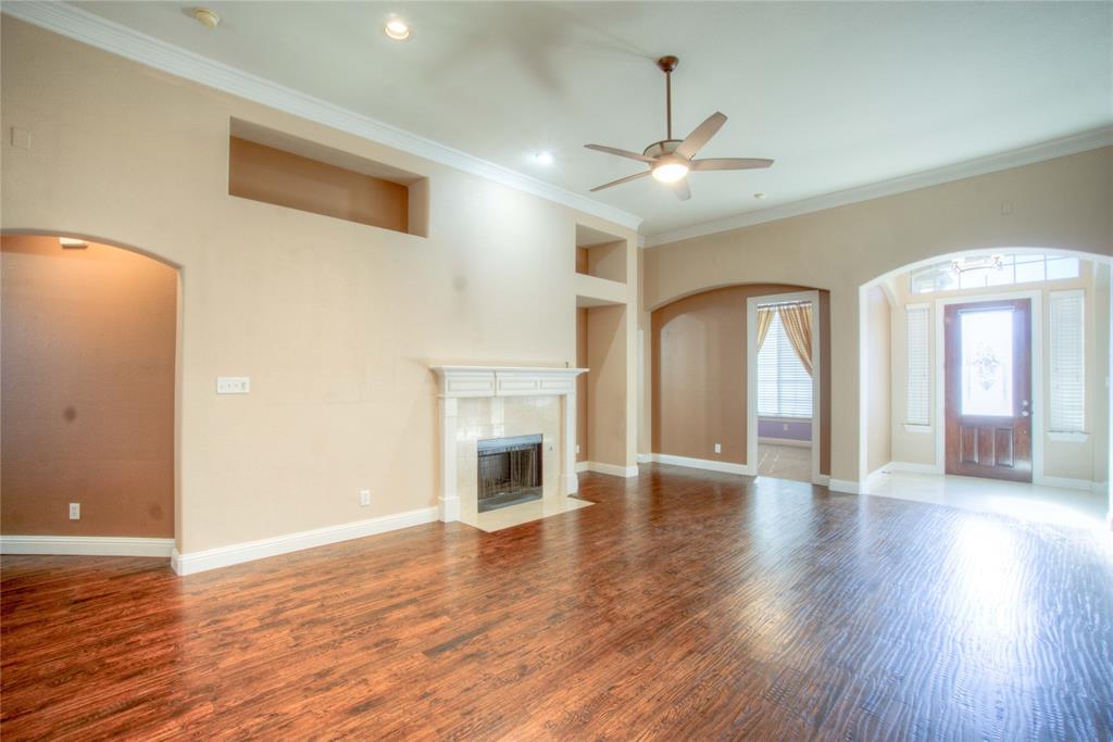 1122 Bridgeway Lane Allen, TX 75013 - Photo 3 of 22 a view of an empty room with wooden floor and a fireplace
