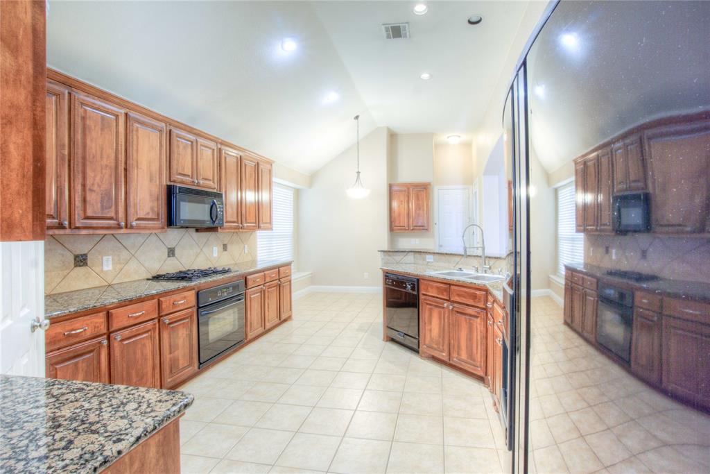 1122 Bridgeway Lane Allen, TX 75013 - Photo 7 of 22 a large kitchen with stainless steel appliances granite countertop a stove top oven a sink dishwasher a dining table and chairs with wooden cabinets