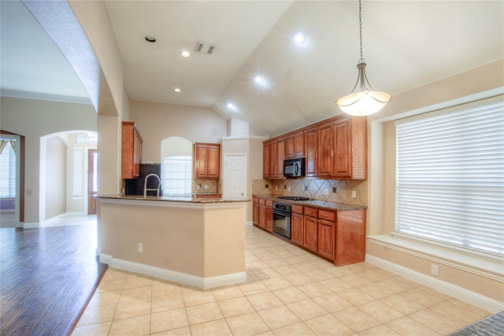 1122 Bridgeway Lane Allen, TX 75013 - Photo 8 of 22 a kitchen with stainless steel appliances granite countertop a refrigerator a stove a sink and a microwave