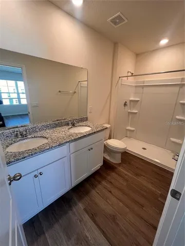 a spacious bathroom with a granite countertop sink mirror and toilet