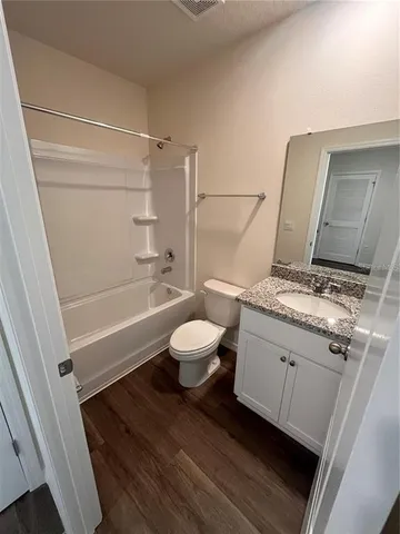a bathroom with a granite countertop sink toilet a mirror and shower