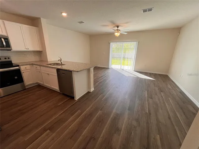 a kitchen with wooden floors and white walls
