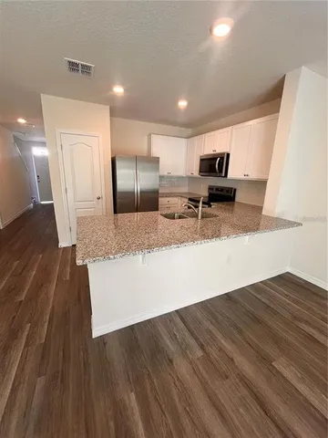 a large kitchen with a large counter top appliances and cabinets