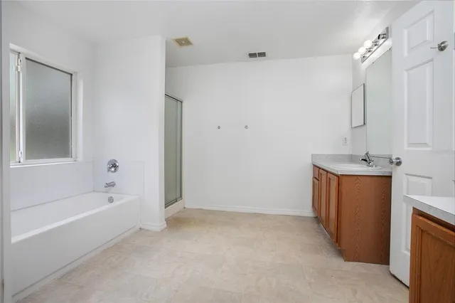 a bathroom with a tub sink and mirror