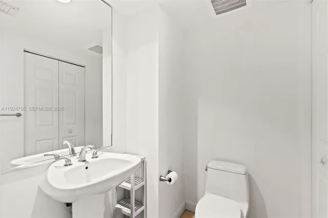 a bathroom with a sink a toilet and mirror