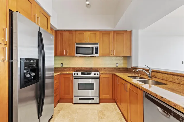 a kitchen with stainless steel appliances granite countertop a stove a sink and a microwave