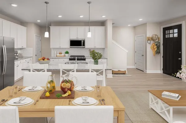 a living room with stainless steel appliances kitchen island granite countertop a dining table chairs refrigerator and sink