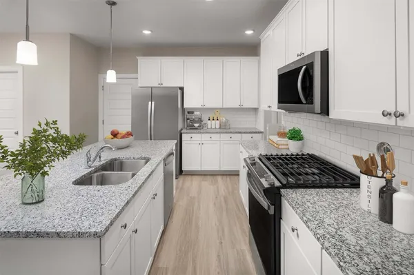 a kitchen with granite countertop stainless steel appliances sink a microwave and cabinets