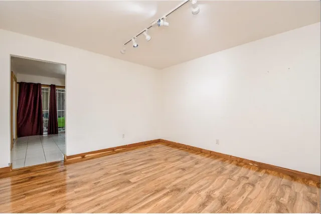 a view of empty room with wooden floor