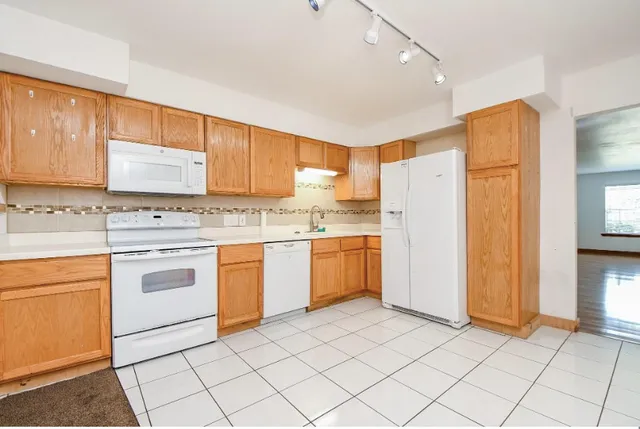 a kitchen with a refrigerator sink and cabinets