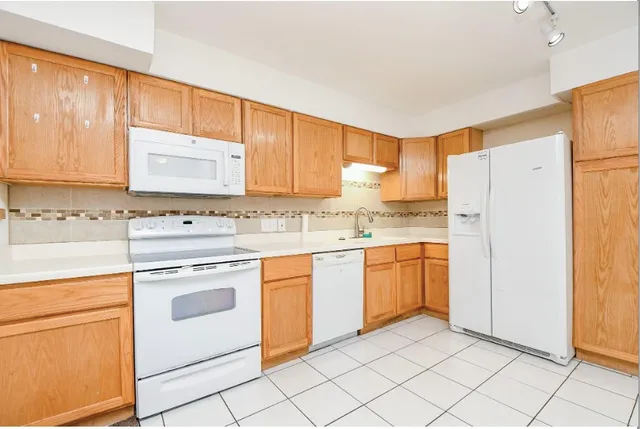 a kitchen with granite countertop cabinets and white appliances