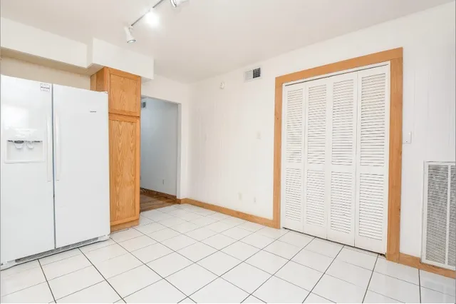 a view of an empty room with wooden floor and a cabinet