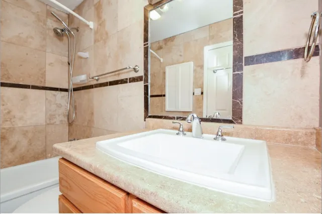 a bathroom with a granite countertop sink and a mirror