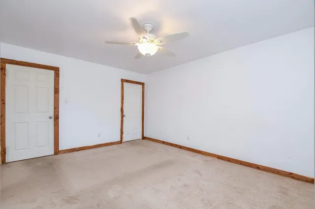 an empty room with a chandelier fan